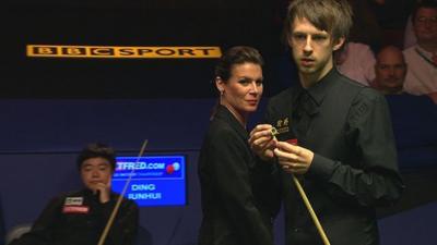 Judd Trump is watched by Ding Junhui & referee Michaela Tabb