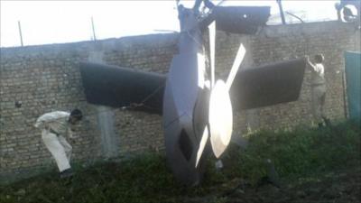 A man next to a damaged helicopter