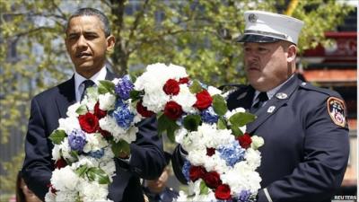 Barack Obama and a New York City firefighter carrying a wreath