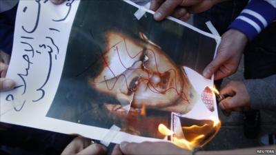 People burning picture of President Bashar al-Assad