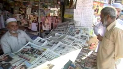 Men standing at a newspaper stall in Abbottabad