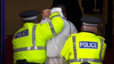 A man is led away by police in Tynecastle