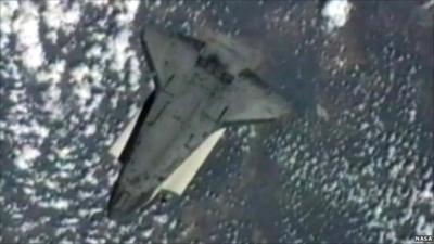 Space shuttle Endeavour mid-back-flip over Earth