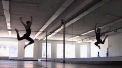 A dancer jumping in front of a mirror