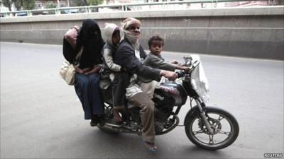 A Yemeni family on motorcycle flees their home