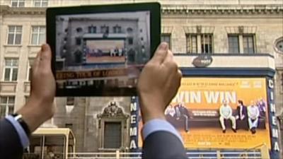 Tablet computer held up to film poster