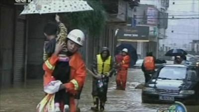 Rescue worker carries a child to safety