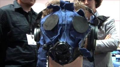 Video gamer wearing gas mask to become immersed in a video game that uses sound