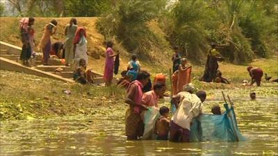 People wash clothes in a lake