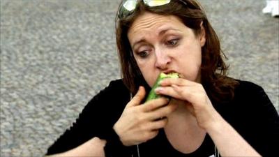 Vegetarian eating a cucumber