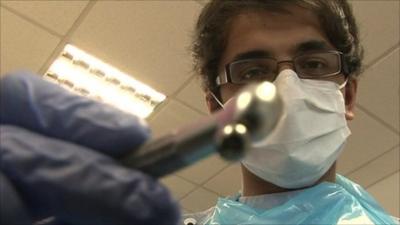 Student dentist using drill simulation device