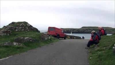 People sitting by the roadside on the Isle of Eigg