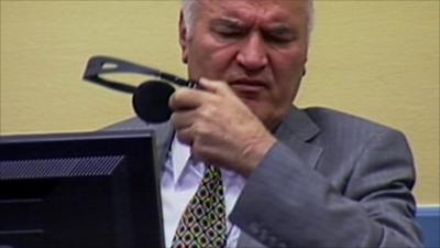 Ratko Mladic removes his headphones in court