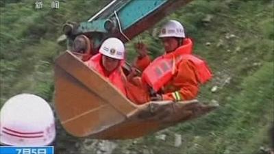 Rescuers in the bucket of a digger