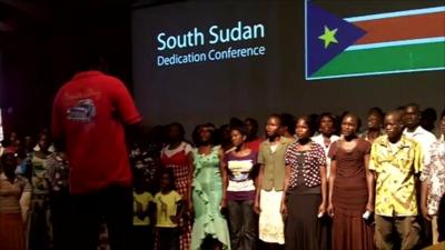 Sudanese people rehearse the national anthem of South Sudan