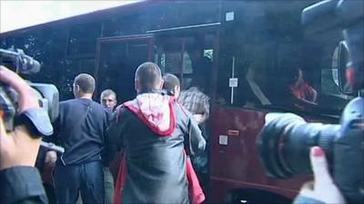 Protester being pushed onto a bus