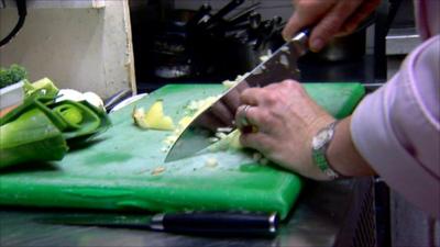 Chef prepares vegetables in a restaurant kitchen