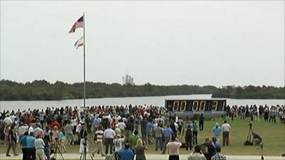 Spectators watch as the countdown clock freezes at 31 seconds to launch