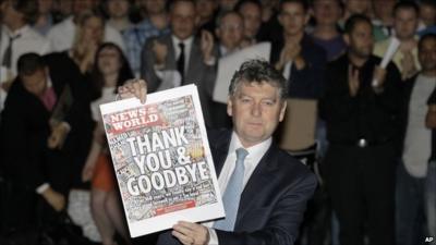 News o the World editor Colin Myler holds up the final edition of the paper