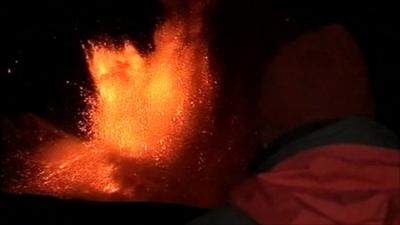 Man watching eruption at Mount Etna