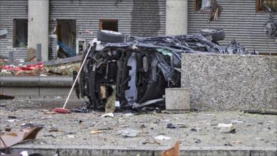 The wreckage of a car lies outside a building in the centre of Oslo
