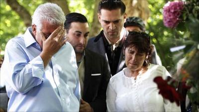 Father Mitch Winehouse, brother Alex, former boyfriend Reg Traviss and mother Janis look at tributes