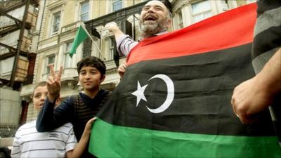 Protesters celebrate outside the Libyan Embassy in London