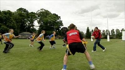 Mark Cueto dummies a pass to Mike Bushell against a tag rugby team