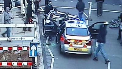 CCTV image of those vandalising a police car