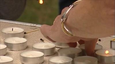 Local residents lighting candles at vigil for Richard Bowes