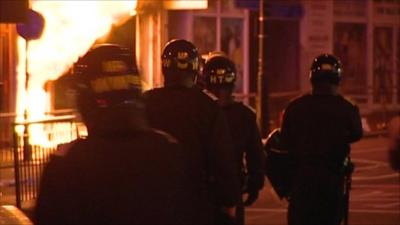 Riot police holding shields