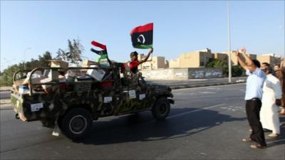 Rebel fighters in Libya wave a flag