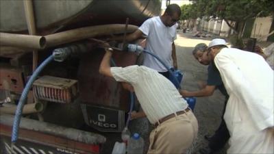 Men gather around a water spout