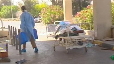 Hospital worker and body on a trolley