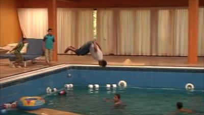 Boy jumping into pool