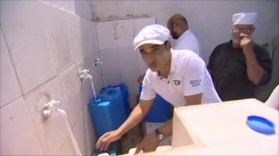 A man collecting water in Tripoli