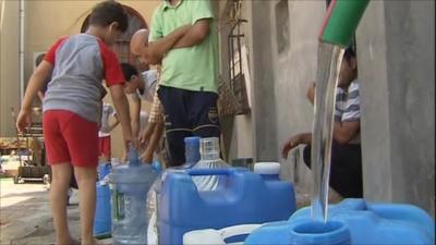 People filling containers with water in Tripoli