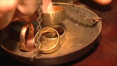 Gold rings being put on scales