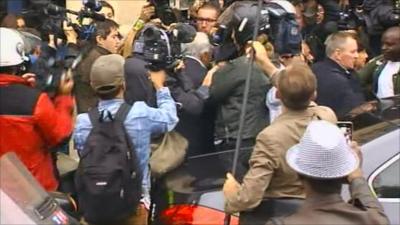 Dominique Strauss-Kahn surrounded by reporters in Paris