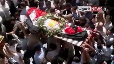 Protesters carry a coffin during funeral procession in Damascus