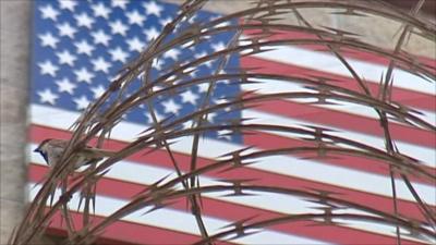 American flag behind wire fence at Guantanamo Bay