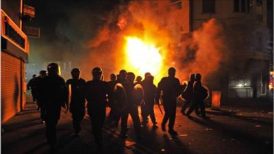 Riot police by a burning building in Croydon