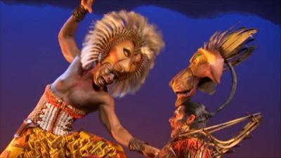 Cast from the Lion King performing on stage