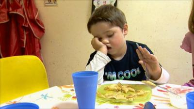 Boy eating his dinner at a table