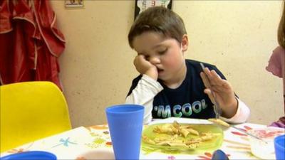 Boy eating his dinner at a table