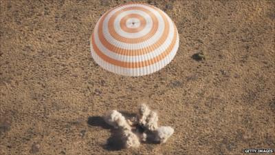 Parachute above plume of dust caused by Soyuz capsule landing in Kazakhstan