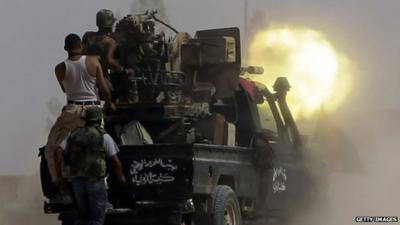 Fighters loyal to Libya's new leaders fire their artillery