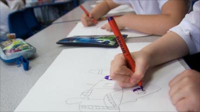 child drawing at desk