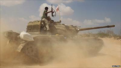 Anti-Gaddafi fighters advance to bomb an area where they exchange fire with Gaddafi loyalists near Herawa