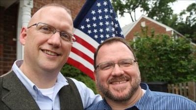 gay soldier and partner in front of US flag